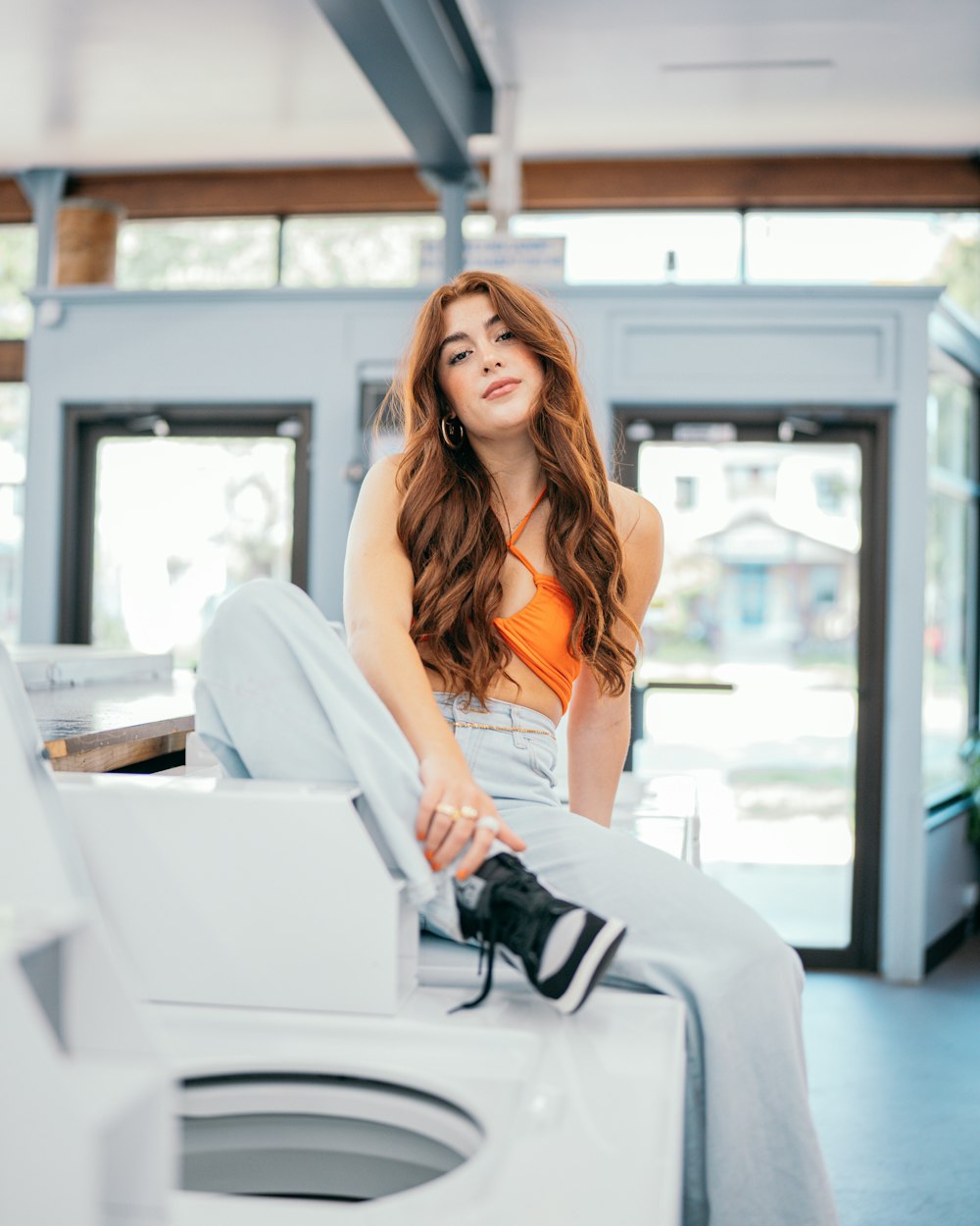 a woman sitting on top of a washing machine