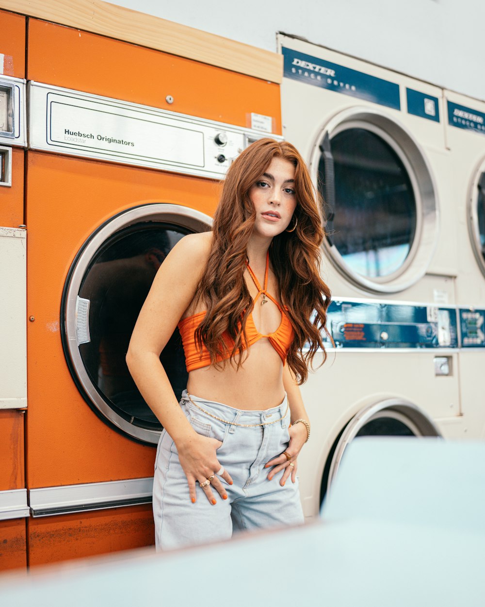 a woman standing next to a washing machine