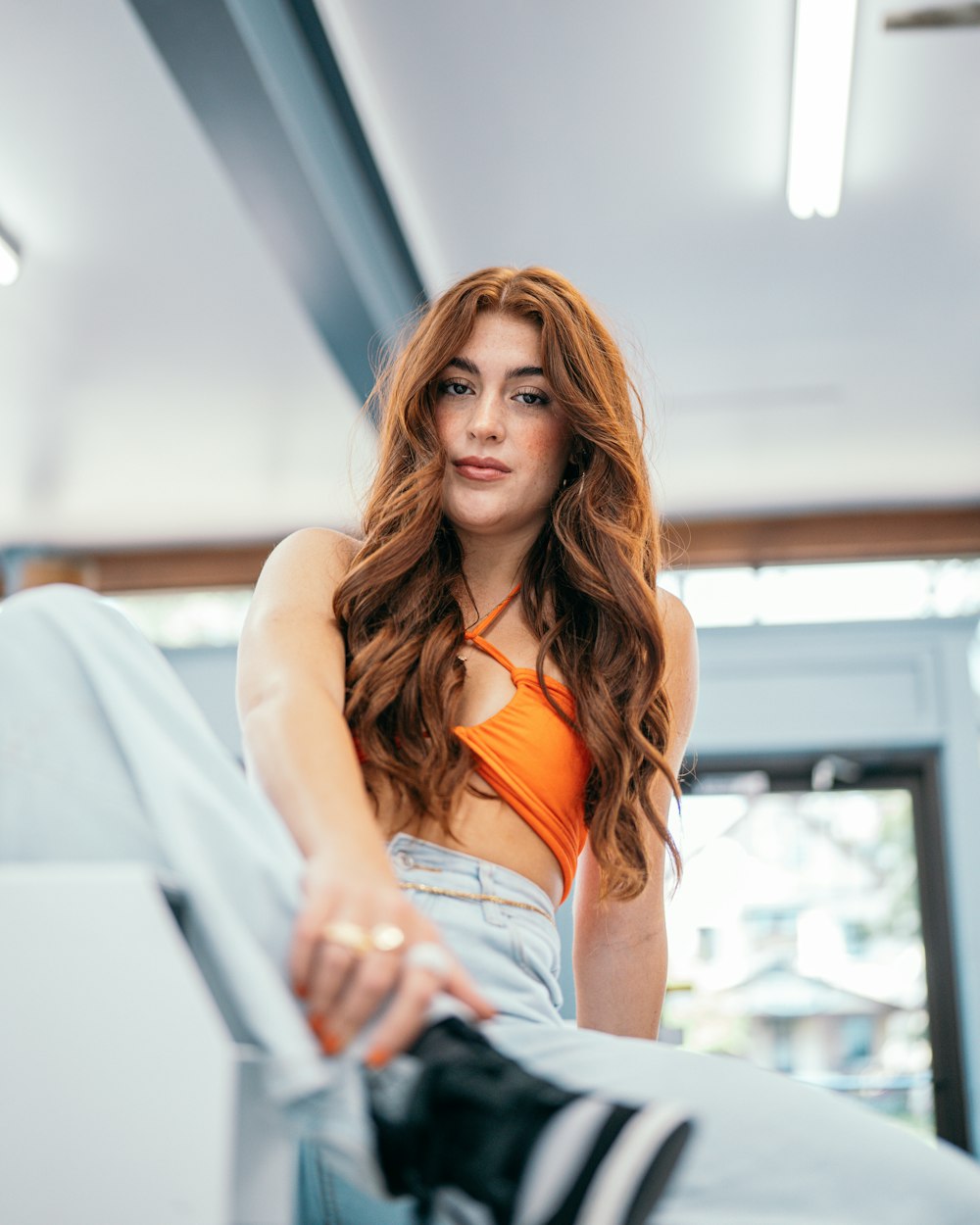 a beautiful young woman sitting on top of a bed