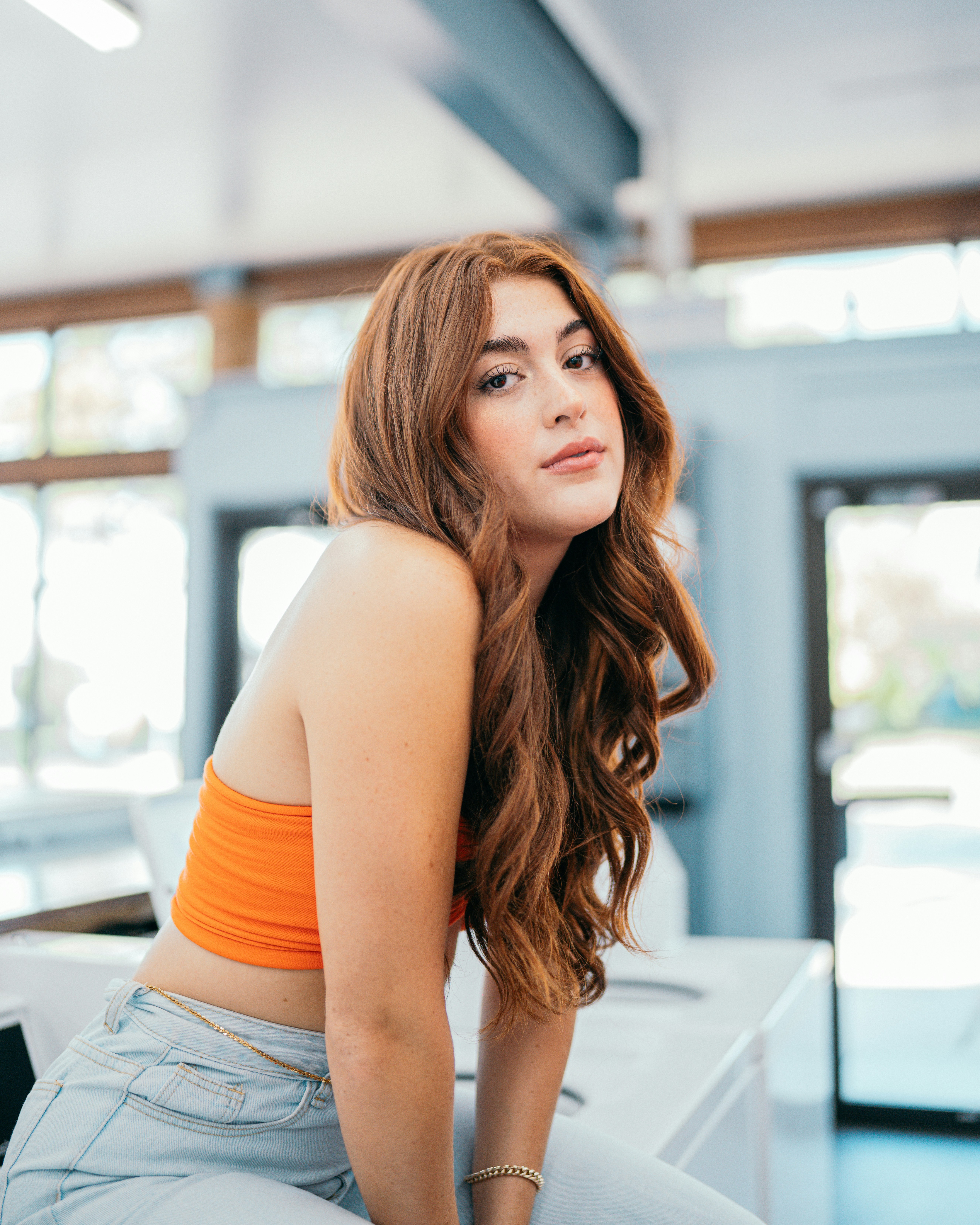 oung woman with voluminous auburn waves, styled with seamless clip-in hair extensions