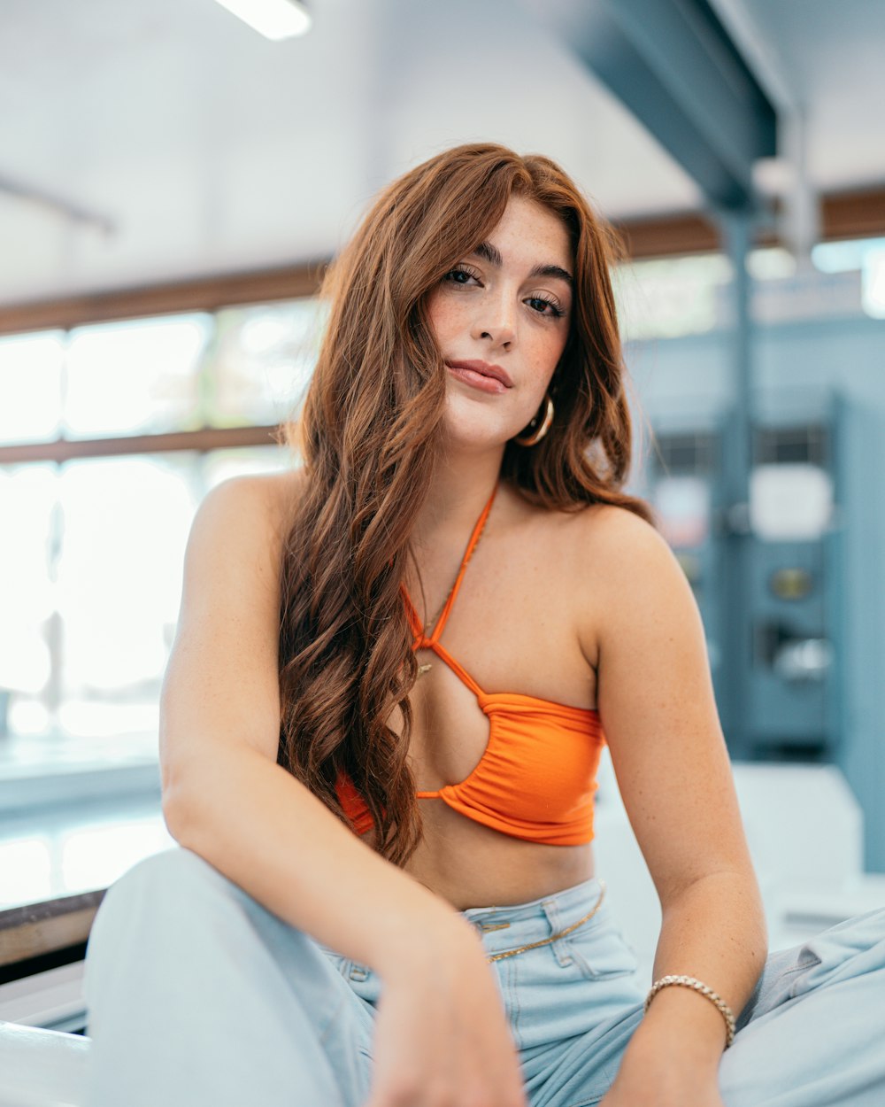 a woman in a bikini top sitting on a bed