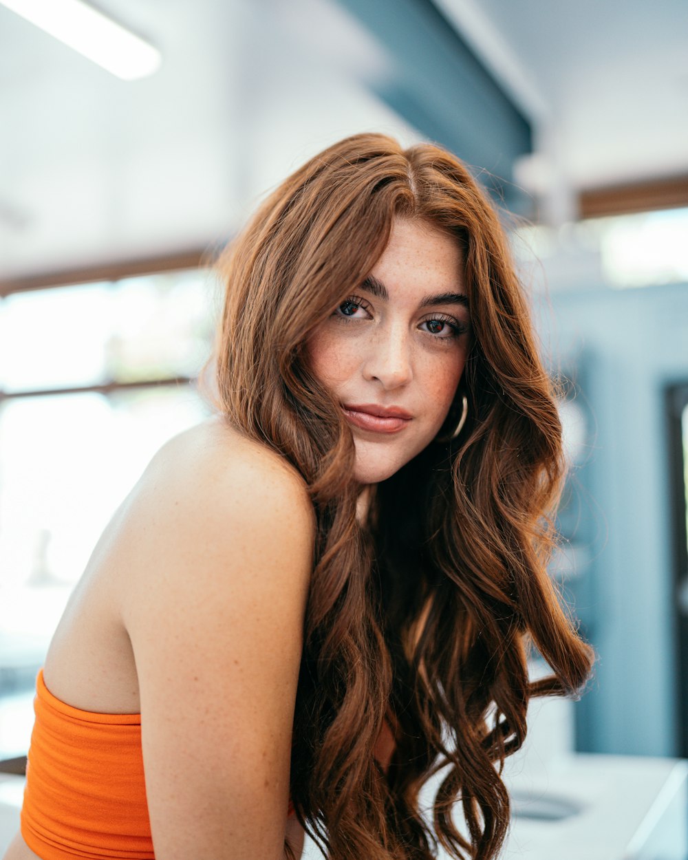 a woman in an orange top is posing for a picture