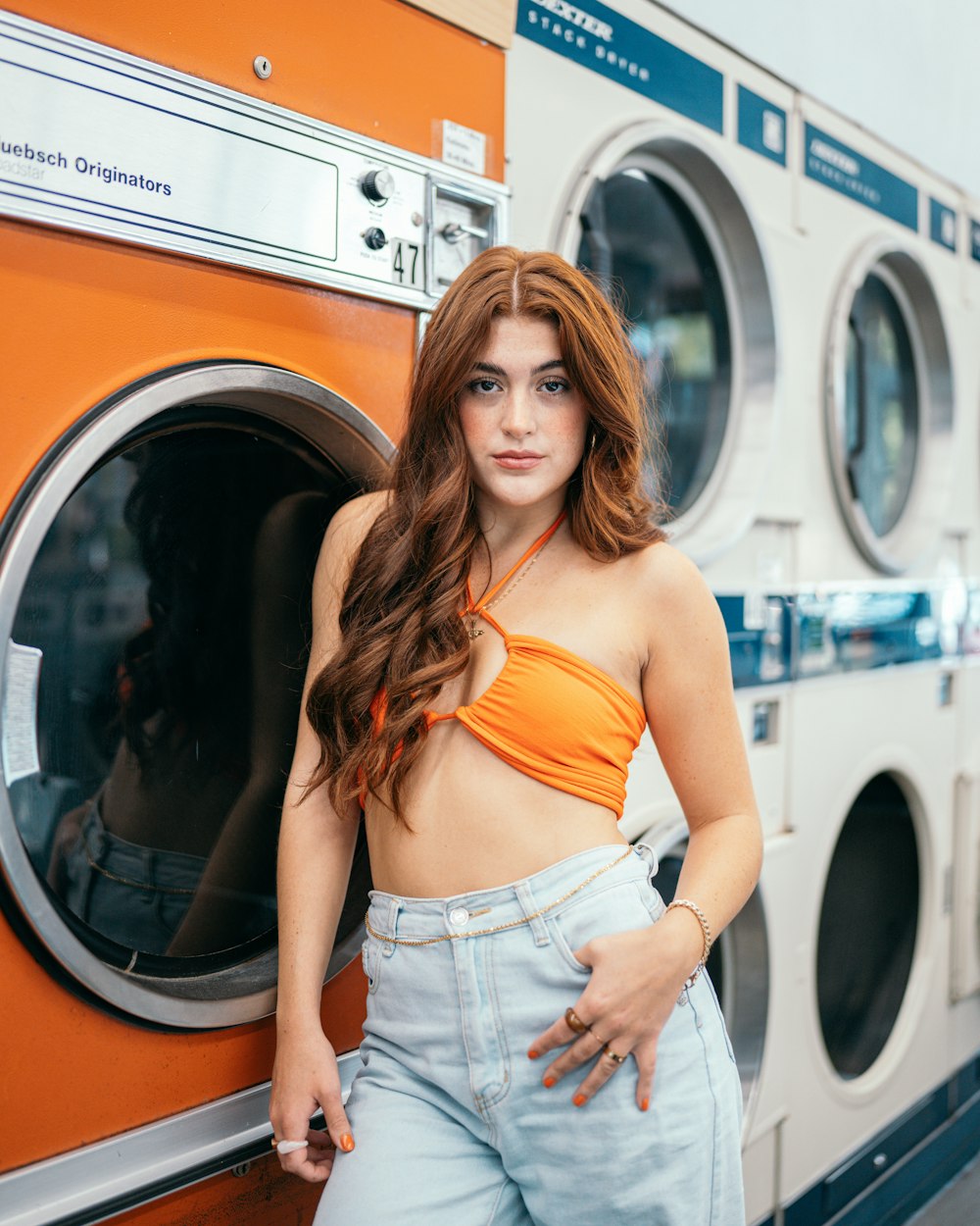 a woman leaning against a washer door