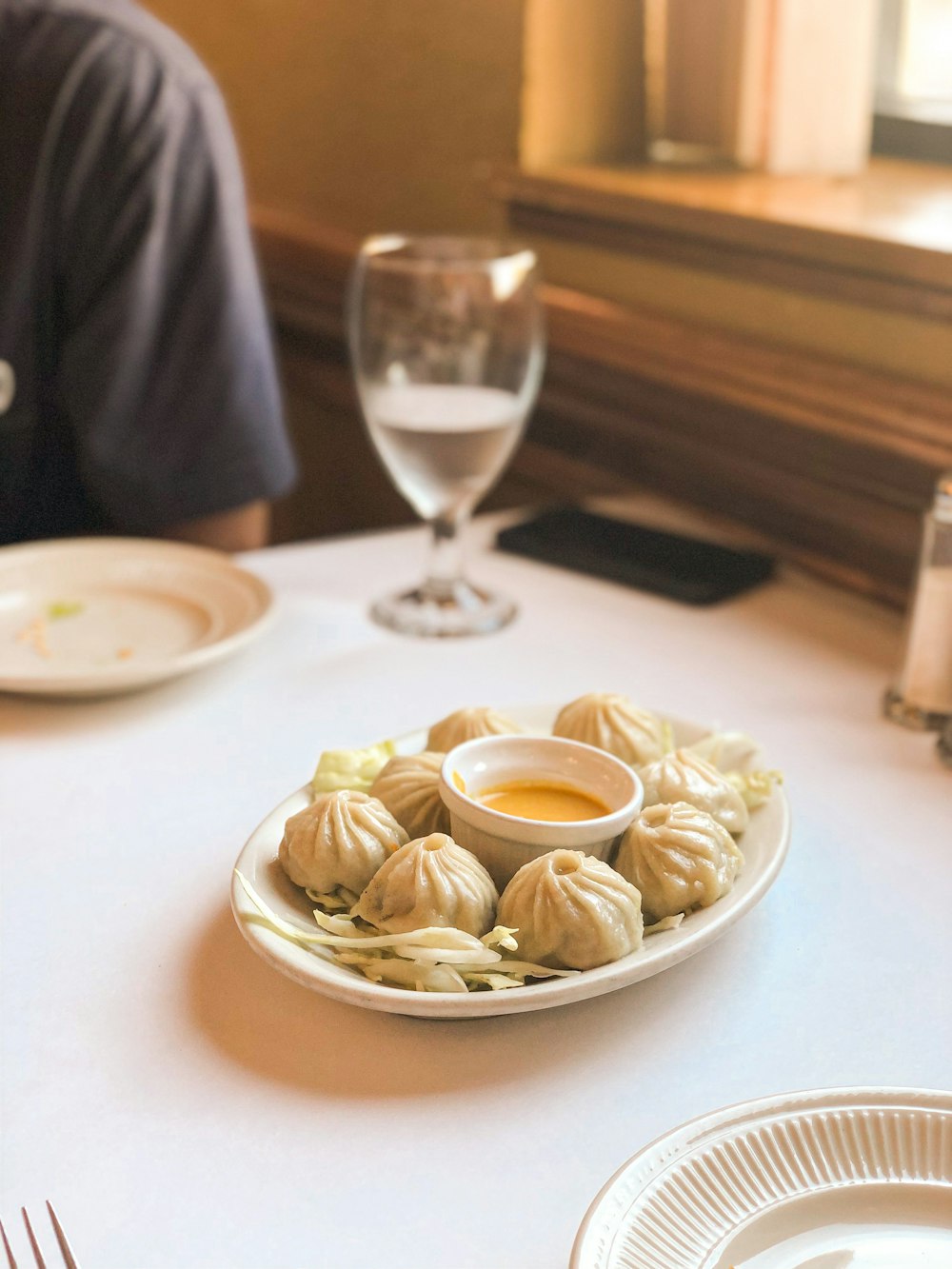 a person sitting at a table with a plate of food