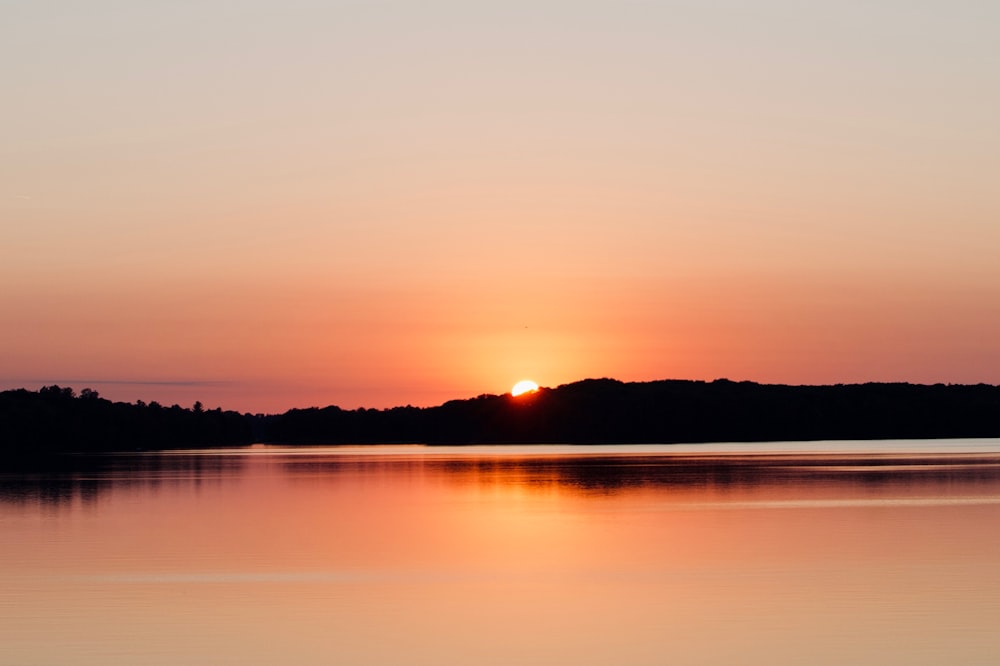 the sun is setting over a body of water