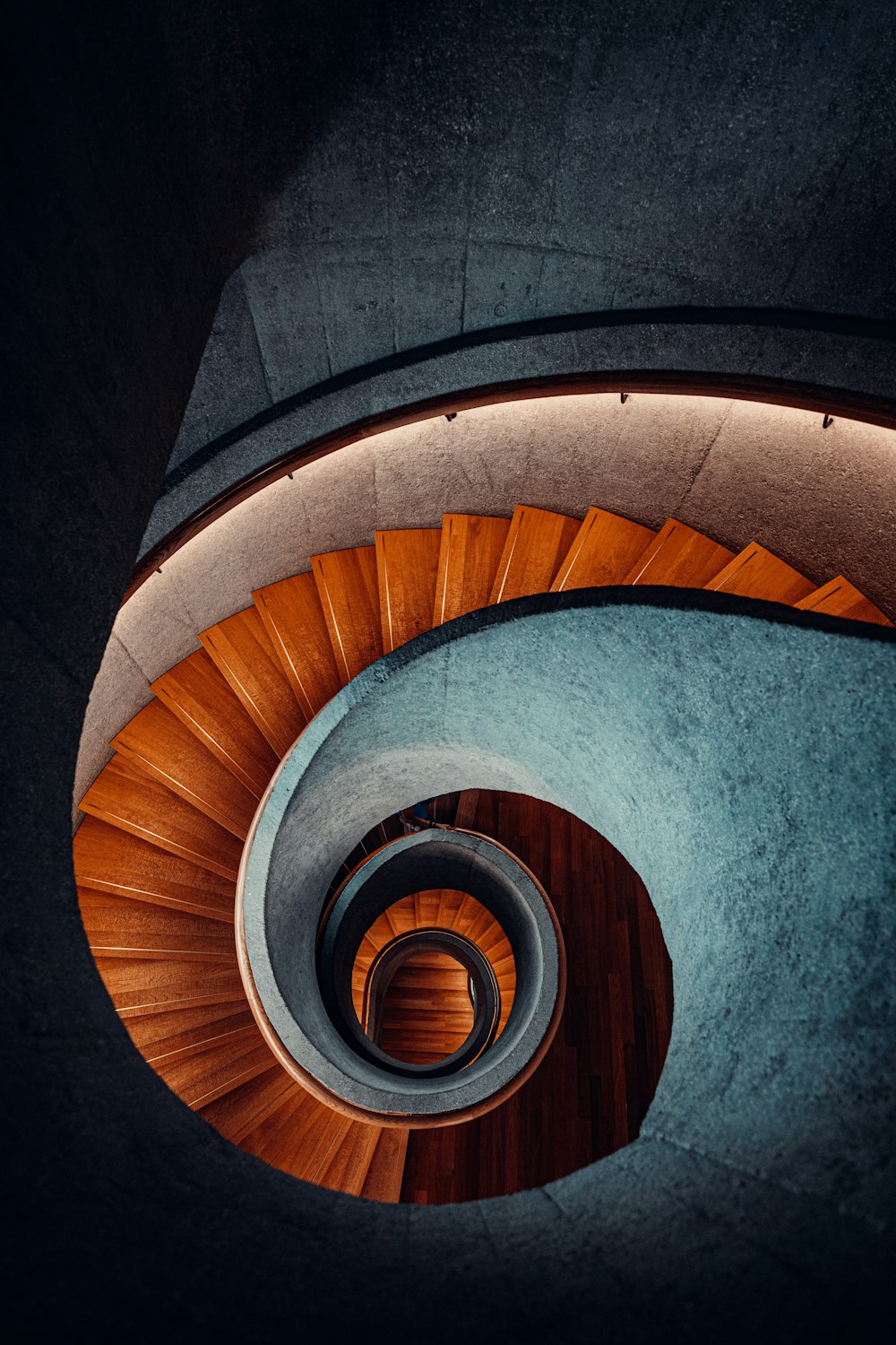 a spiral staircase in a building with a wooden floor