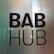 The image features bold black text that reads 'BAB HUB' against a partially reflective glass surface. There is a subtle gradient in the background, transitioning from a greenish hue on the left to a warmer tone on the right. The reflection on the glass suggests a possible indoor environment.
