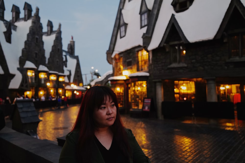 a woman standing in front of a row of buildings