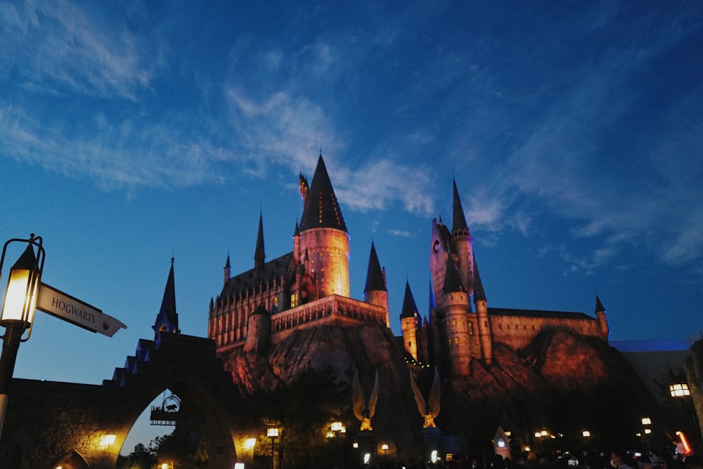 a castle lit up at night with people walking around