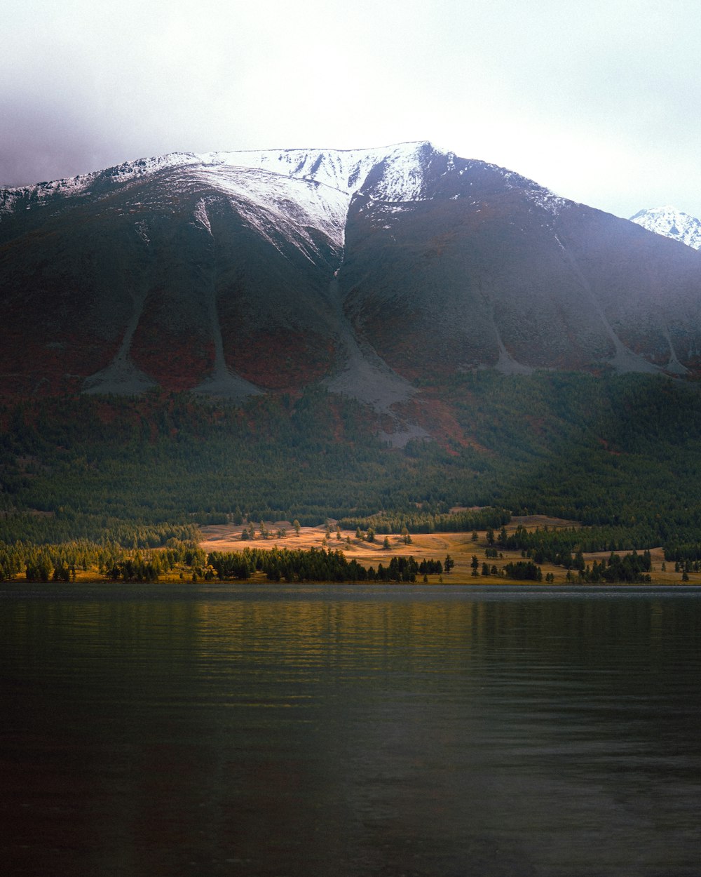 a mountain range with a lake in the foreground