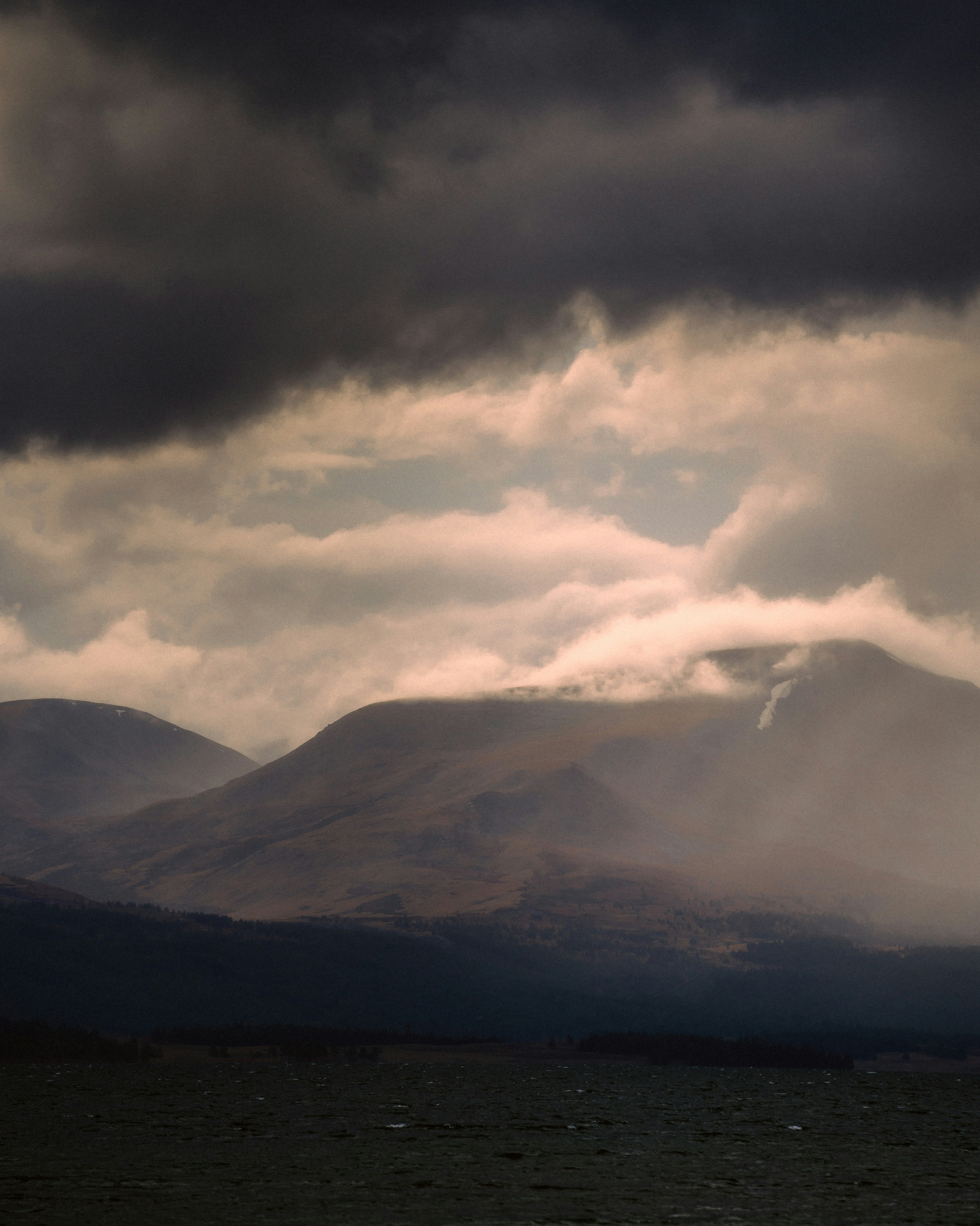 a large mountain covered in clouds in the distance
