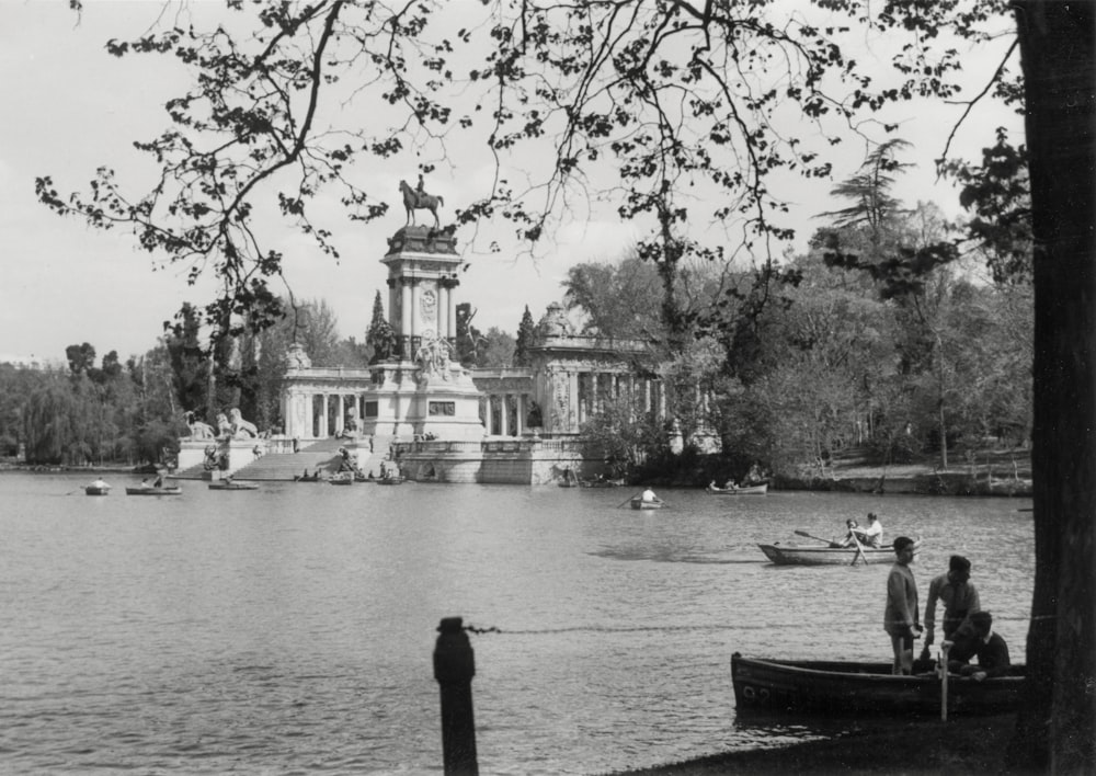 a black and white photo of people on a boat in a lake
