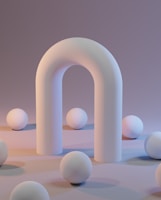 a group of white balls sitting next to a white arch