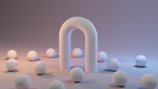a group of white balls sitting next to a white arch