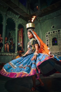 a woman in a colorful dress is performing a dance