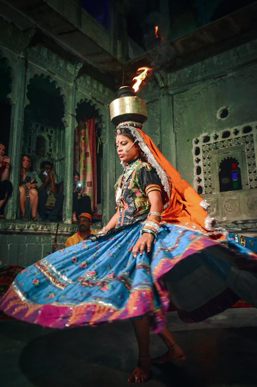 a woman in a colorful dress is performing a dance