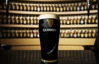 a glass of guinness sitting on top of a table