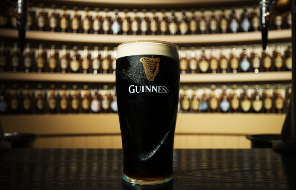 a glass of guinness sitting on top of a table