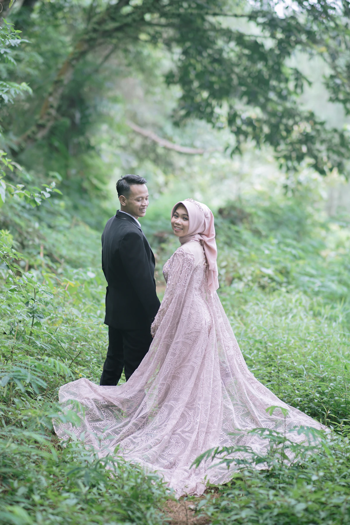 A couple standing among trees in soft light