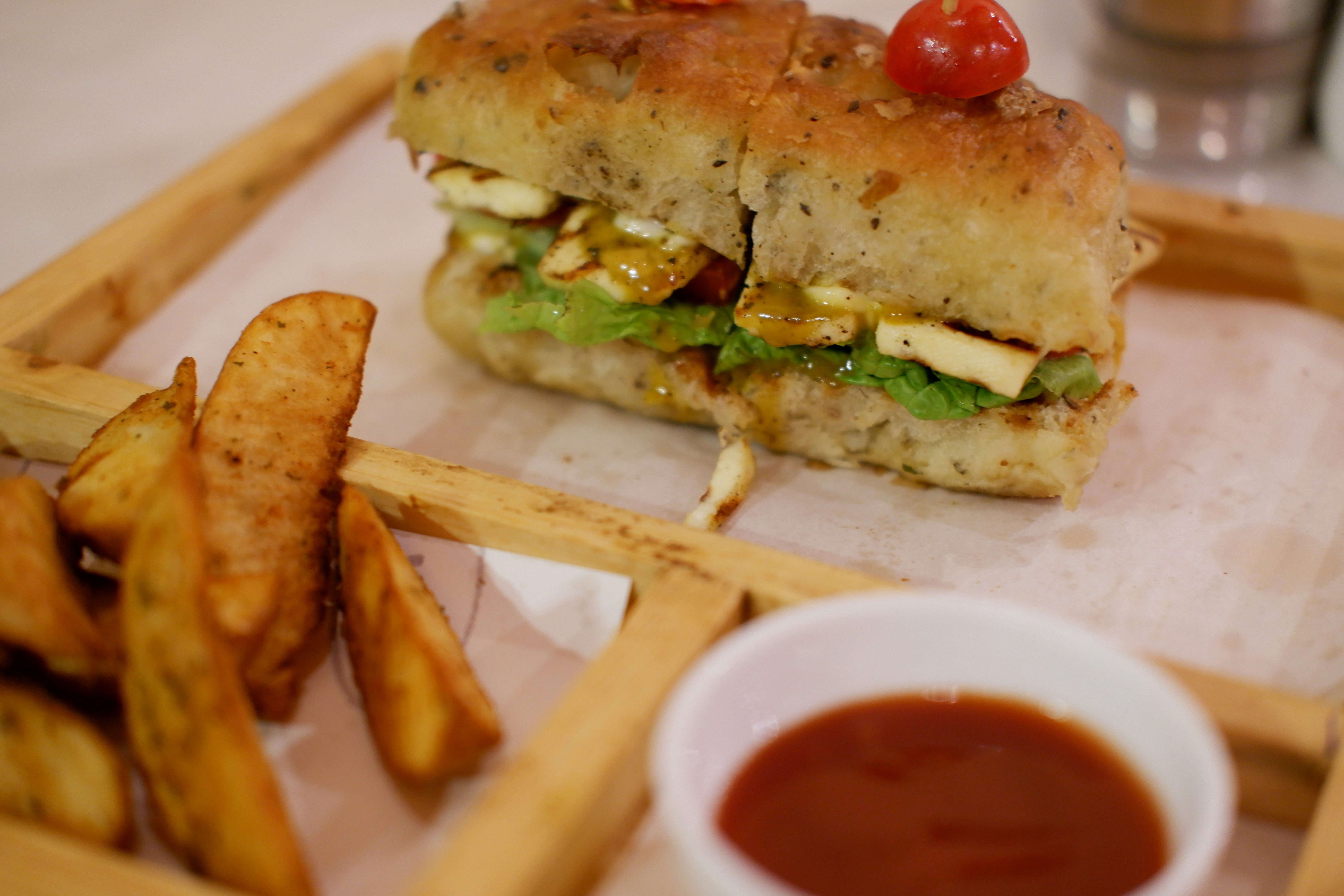 un primo piano di un panino e patatine fritte su un vassoio