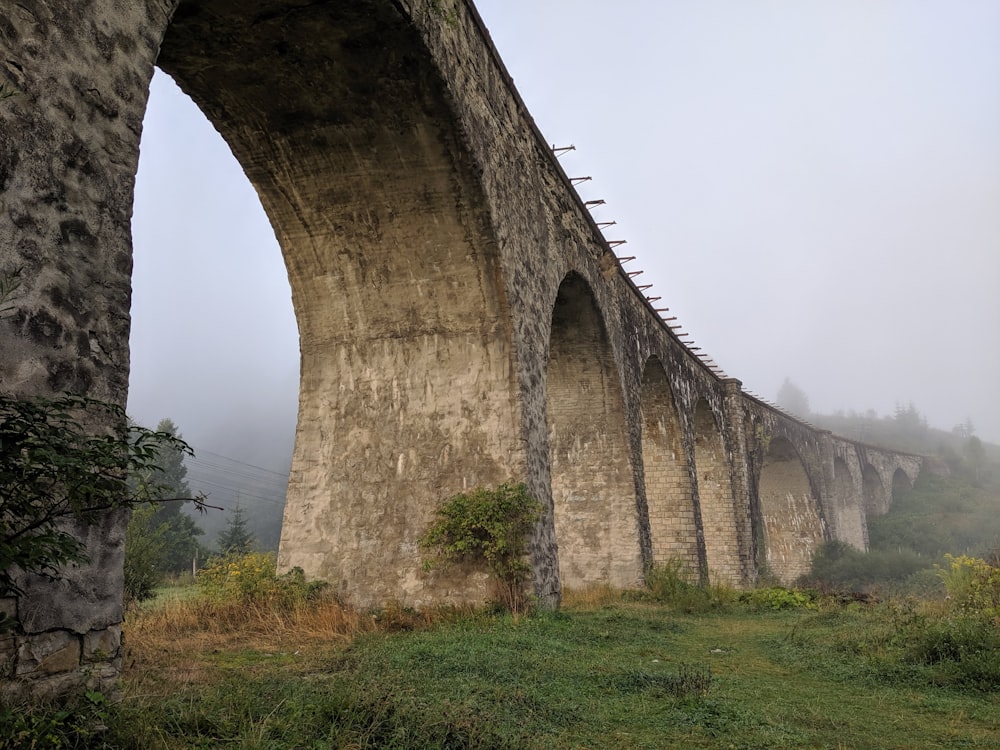 a stone bridge over a lush green field