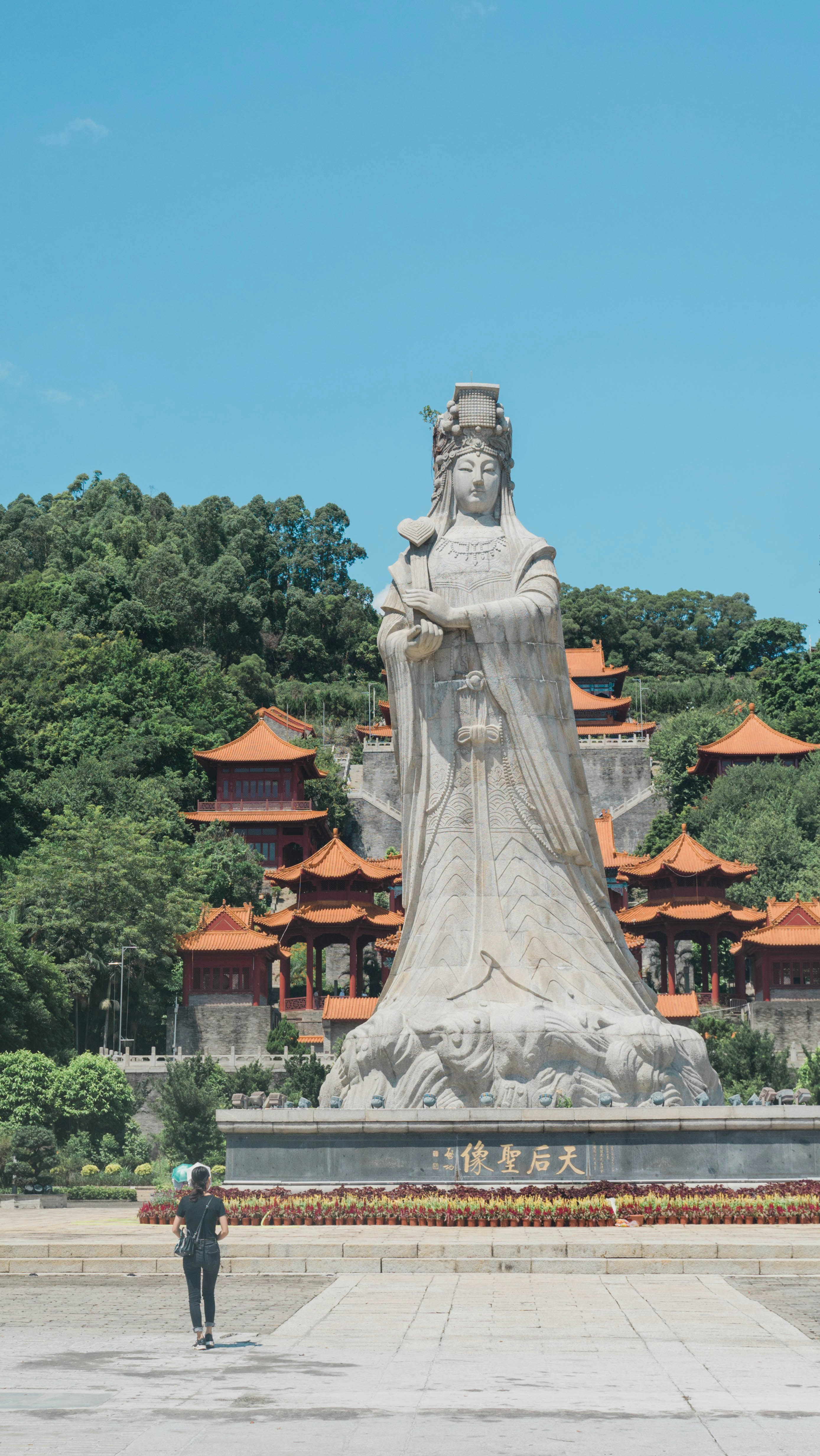 a person standing in front of a large statue