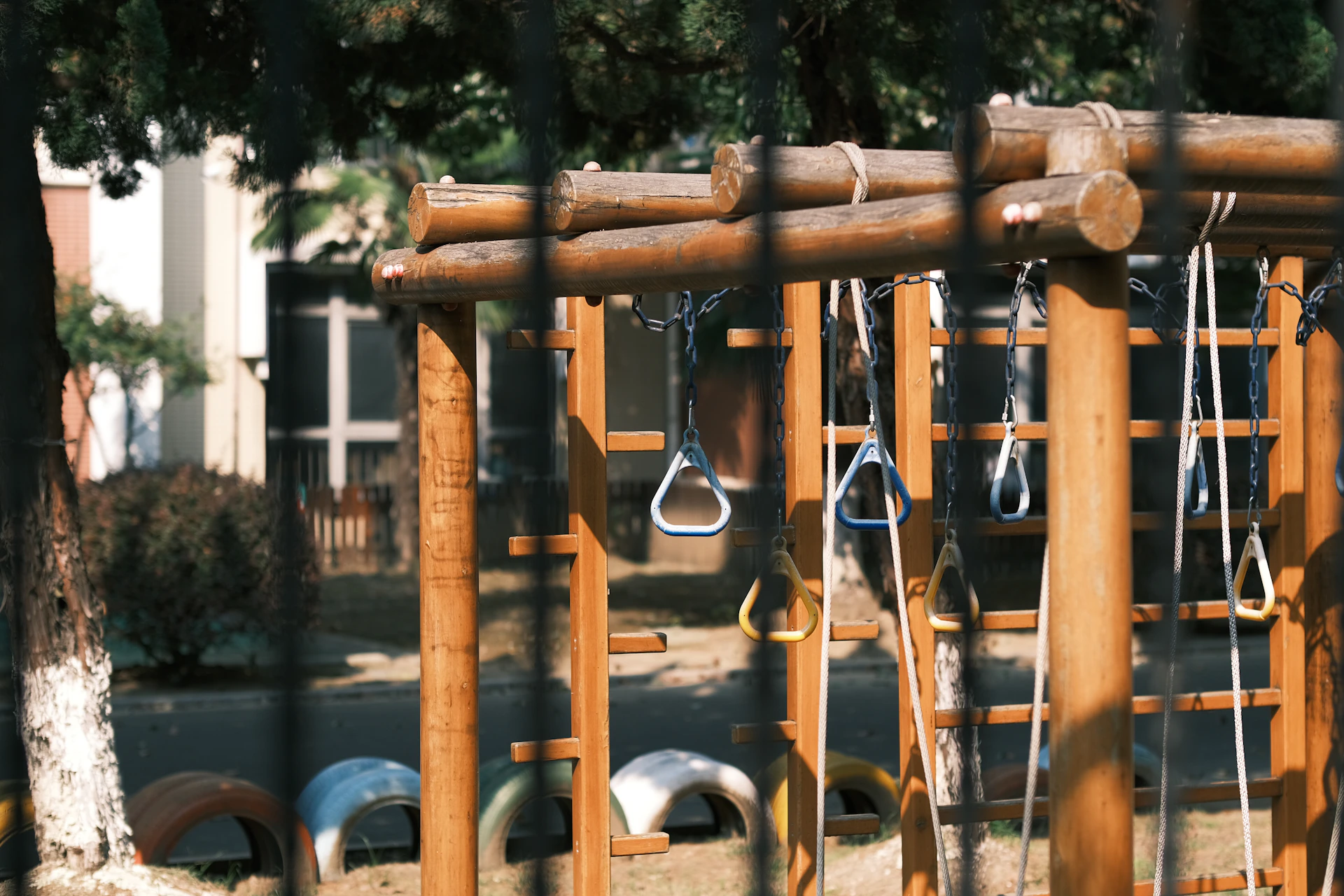 a wooden play structure with several pairs of scissors hanging from it