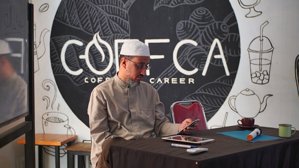 a man sitting at a table with a tablet