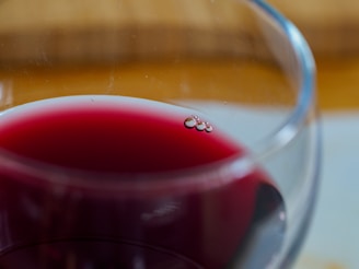 A close-up of a wine glass filled with red wine.
