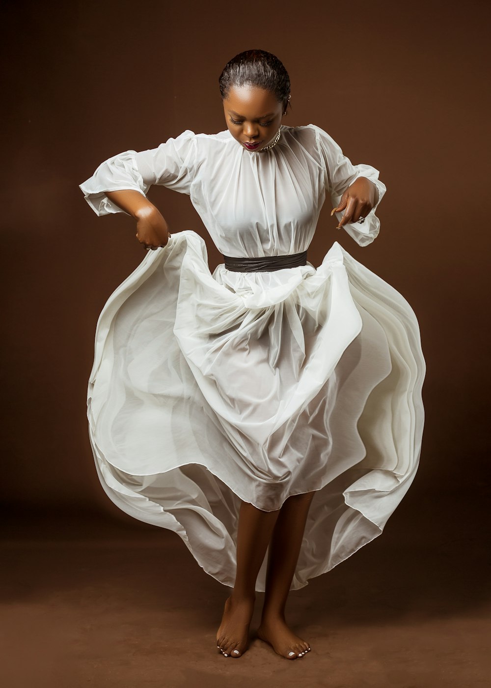 Una mujer con un vestido blanco está bailando