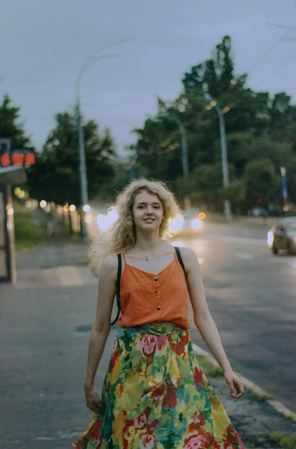 a woman standing on the side of a road