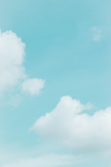 A serene blue sky with soft clouds, evoking calm and inspiration.