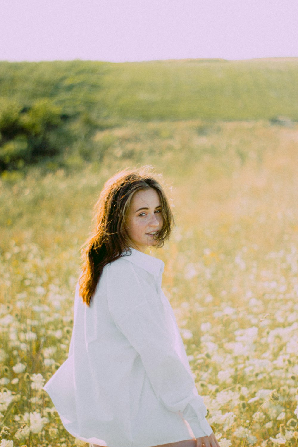 uma mulher em pé em um campo de flores