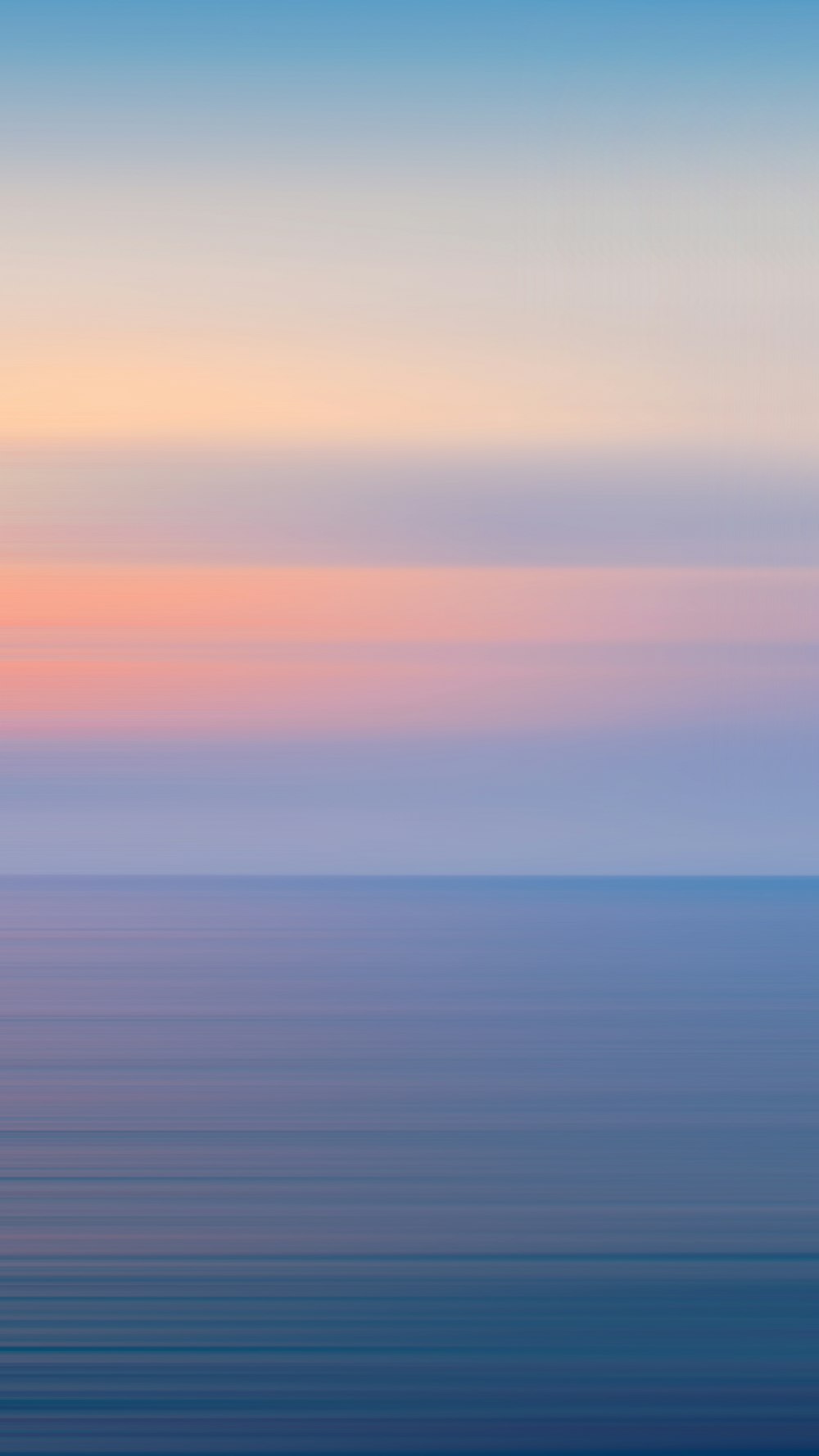 a large body of water with a sky in the background