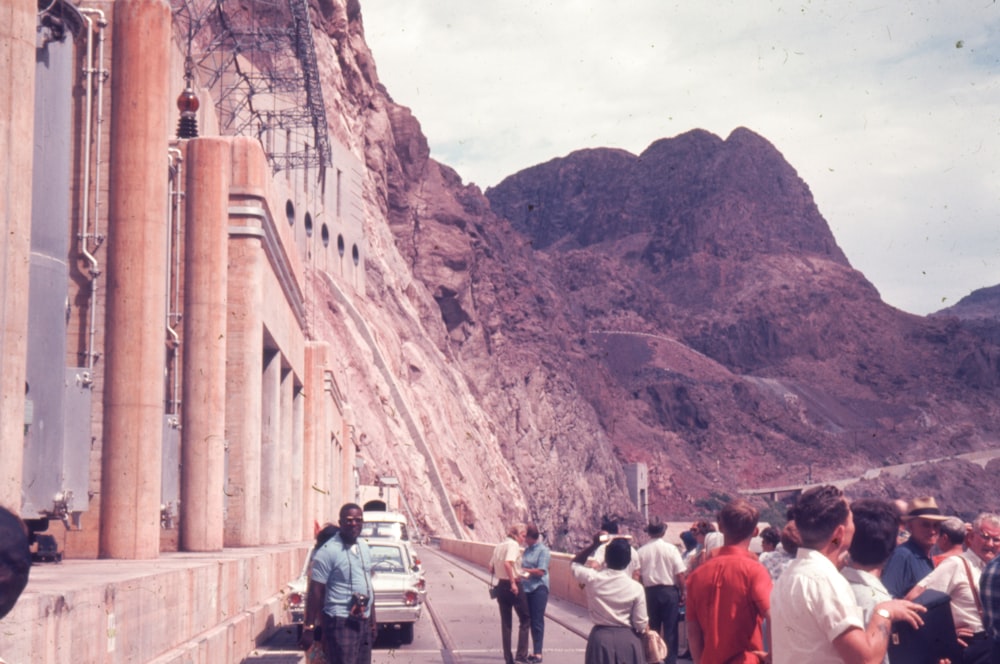 a group of people standing next to a mountain