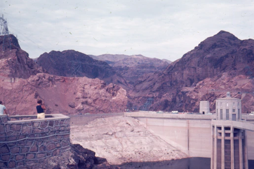 A panoramic view of a hydroelectric dam surrounded by rugged Afghan mountains.