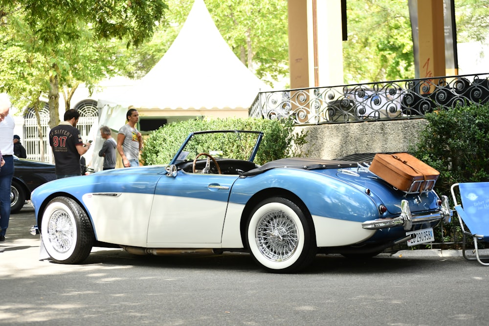 a blue and white car parked on the side of the road