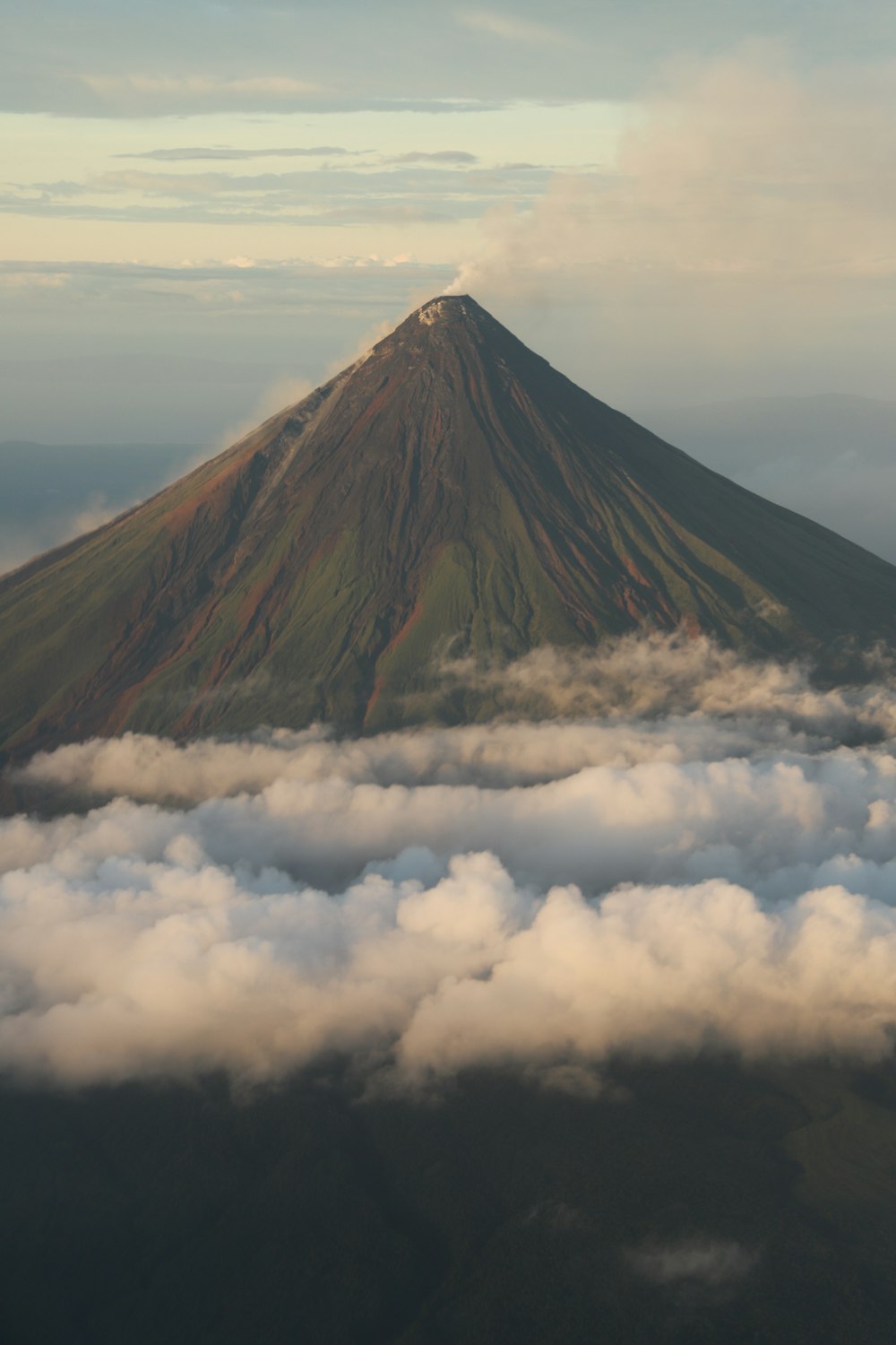 Una montaña muy alta rodeada de nubes en el cielo