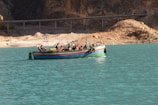 Tourists enjoying a guided boat ride surrounded by the striking hues of the lagoon's seven colors.