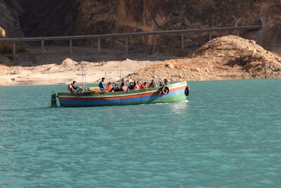 Tourists enjoying a guided boat ride surrounded by the striking hues of the lagoon's seven colors.
