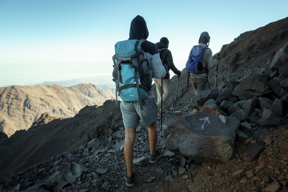 a group of people hiking up a rocky mountain