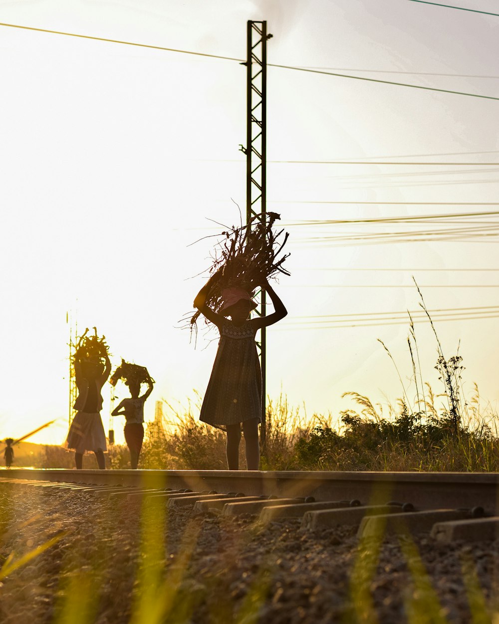 um par de pessoas de pé ao lado de um trilho de trem