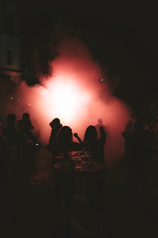 a group of people standing around a table in the dark