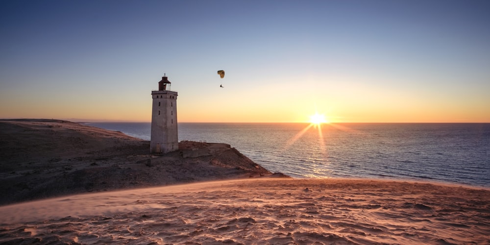 a lighthouse sitting on top of a sandy beach
