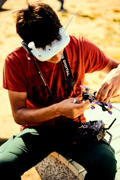 A pilot wearing a neural BCI headset controlling a drone over rugged terrain with AR displays.