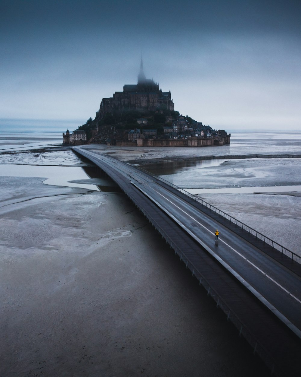 un pont sur un plan d’eau avec un château en arrière-plan