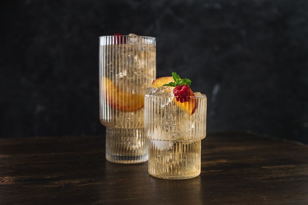 a couple of glasses filled with drinks on top of a table