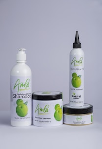 A set of four hair care products with white packaging, each featuring the word 'Amla' and an image of green fruit. The products include a herbal conditioning shampoo, herbal hair treatment, herbal hair oil, and herbal hair food.