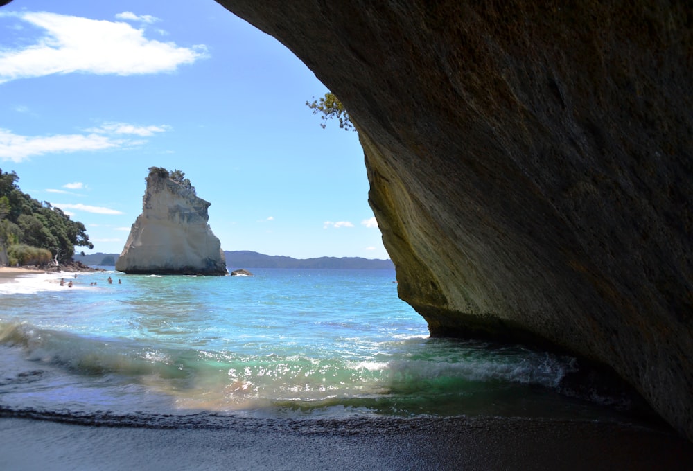 a view of a beach from inside a cave