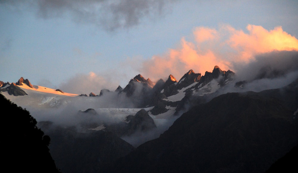 Una vista de una cadena montañosa con nubes en el cielo